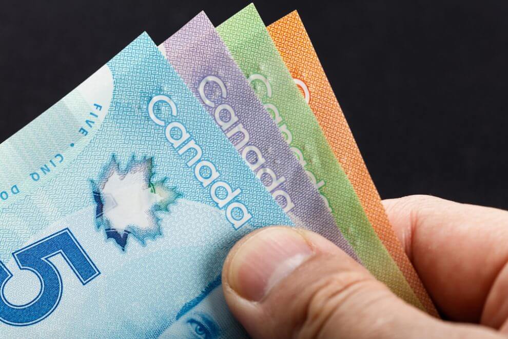 A man holding Canadian money