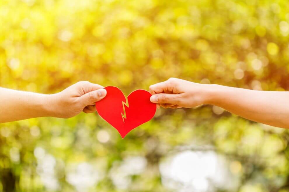 A paper heart is ripped in half by an ex couple.