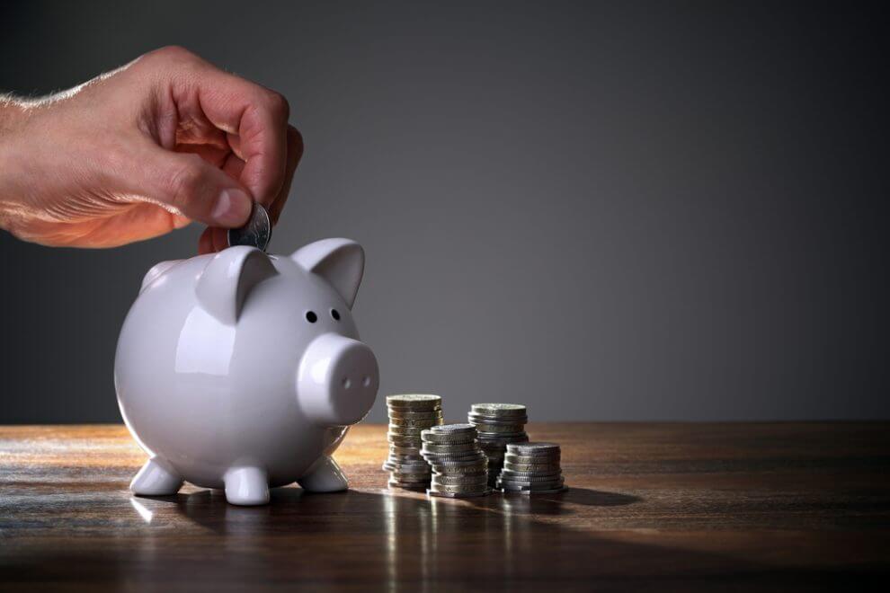 Inserting coin into piggy bank