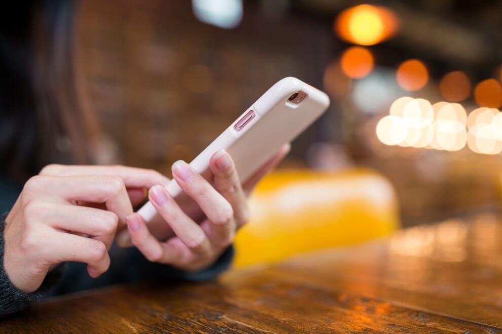 A woman texting on her cell phone in a coffee shop
